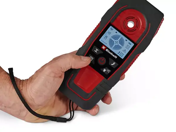 Digitální detektor Einhell TE-MD 80 držený za popruh, na displeji jsou vidět naměřené výsledky.